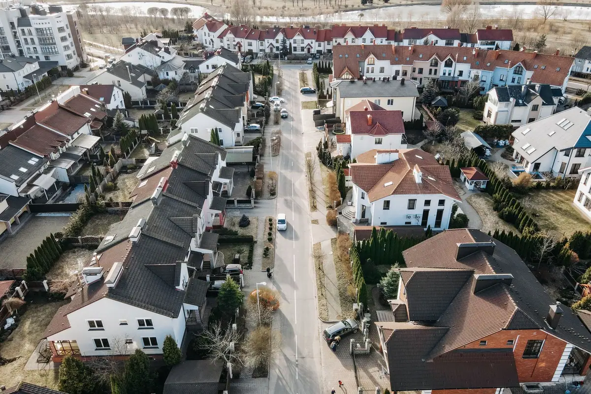 Aerial view of a neighbourhood street lined with white and brick houses